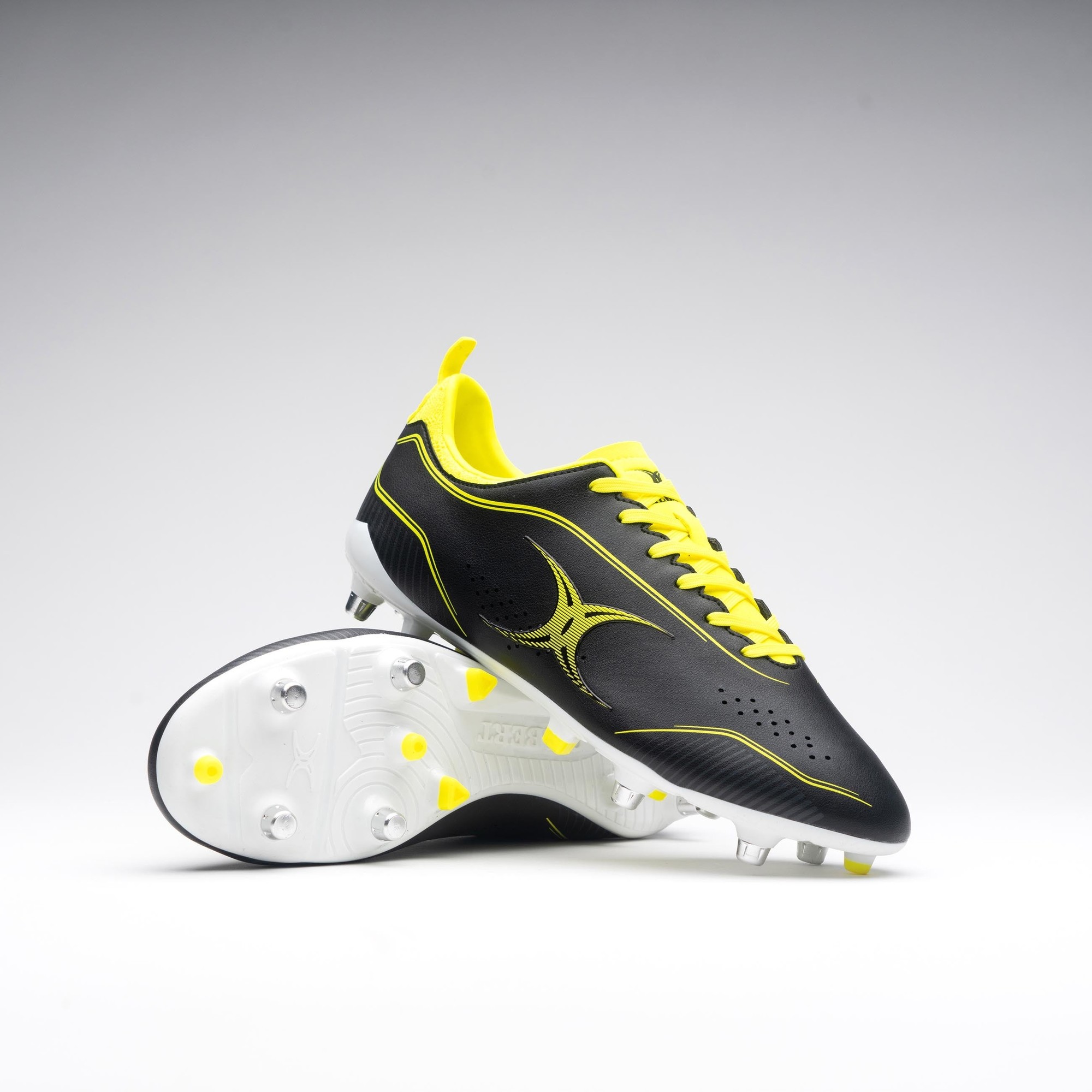 Black rugby boots with fluo yellow accents, featuring a sleek design, textured upper, and six studded outsole for traction on the field.
