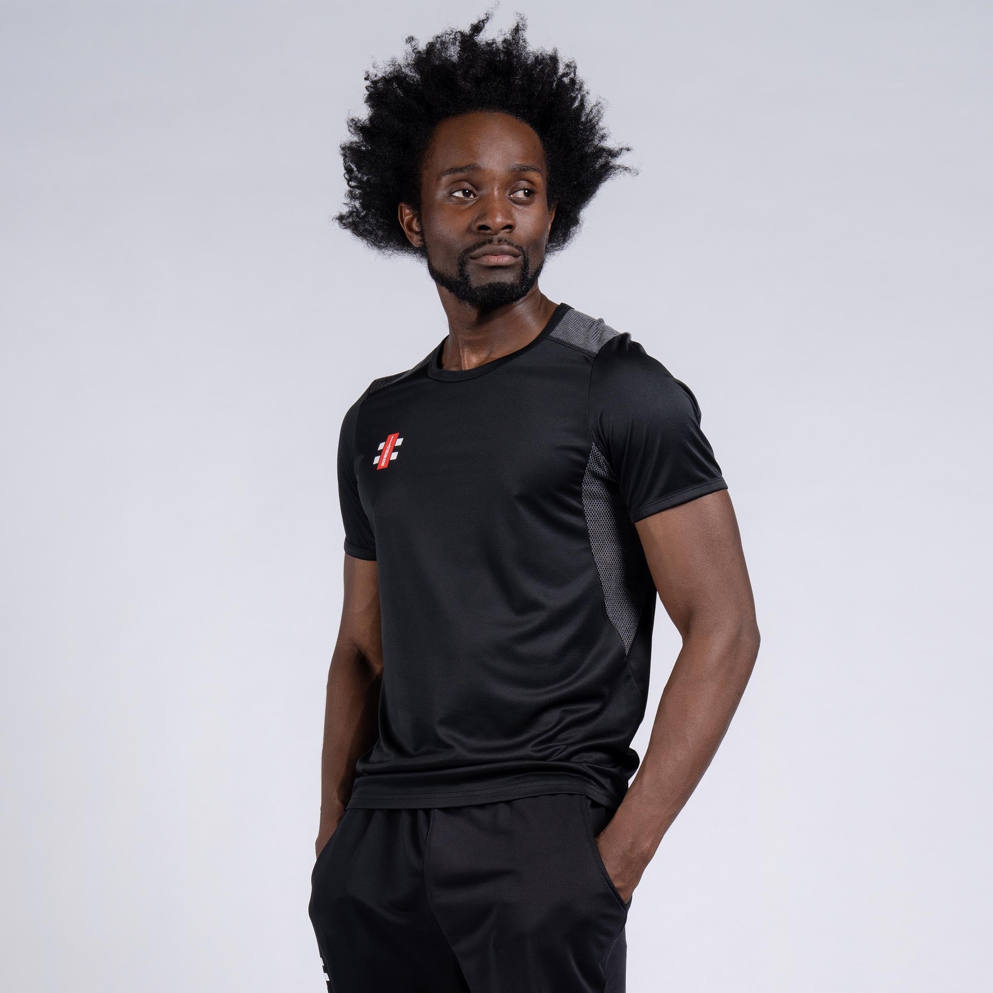 Black short sleeve junior t-shirt by Gray-Nicolls, featuring a smooth, lightweight fabric with a logo on the chest and contrasting gray panels on the shoulders.