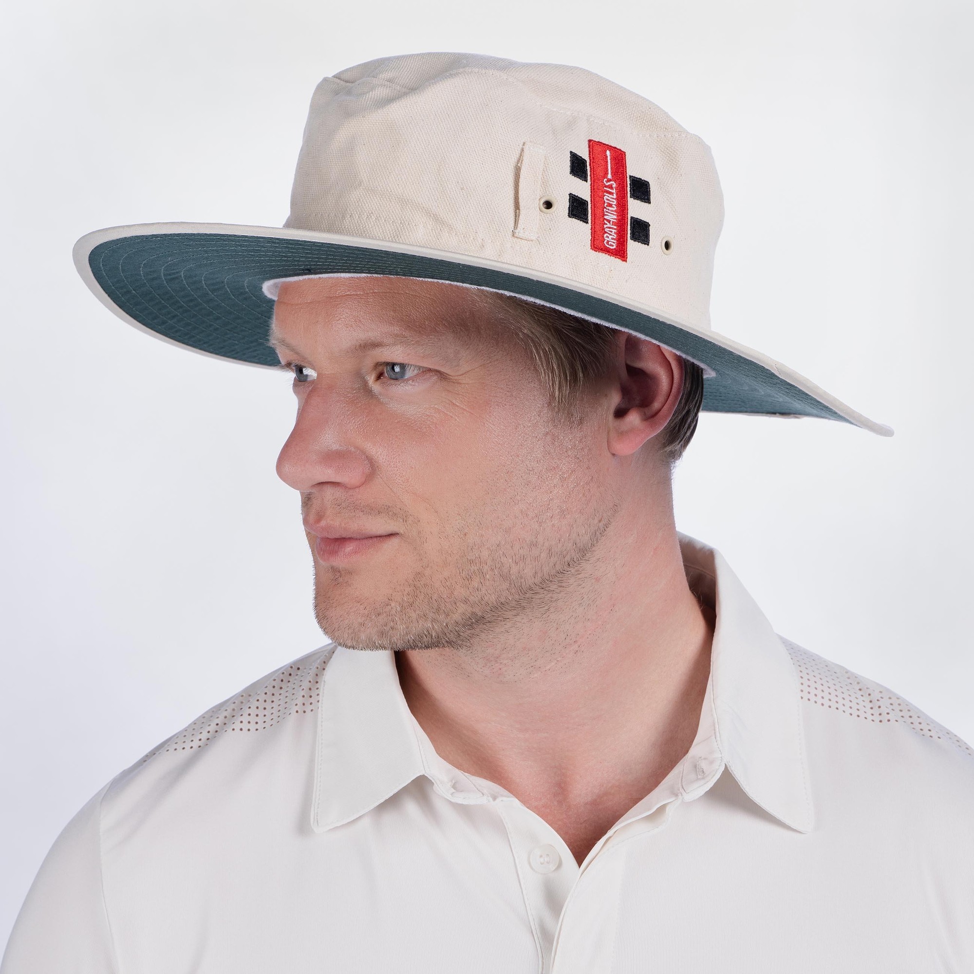Gray-Nicolls sun hat featuring a cream body, contrasting teal brim, and a red logo tag, designed for sun protection in various outdoor activities.