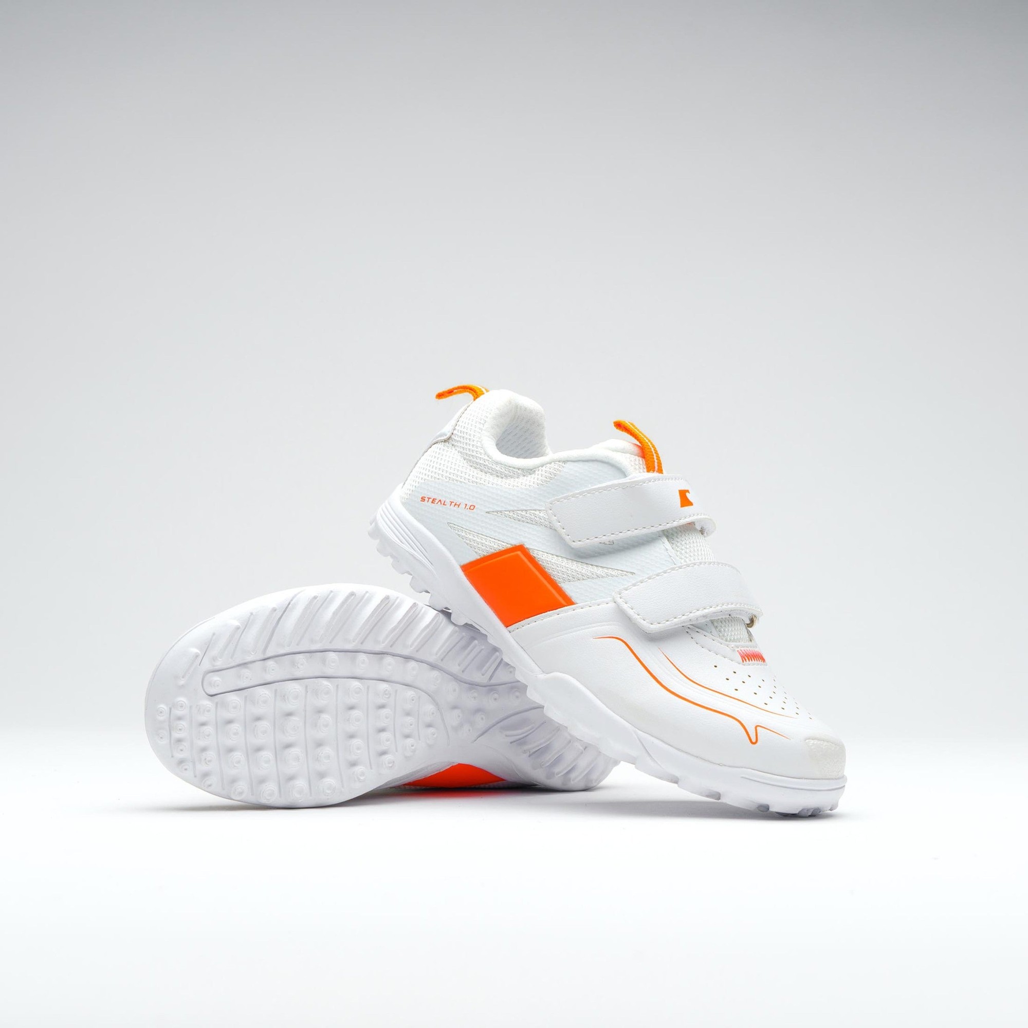 White Grays Stealth Mini Shoe featuring orange accents, a sleek design, dual Velcro straps, and a textured rubber sole for enhanced grip.