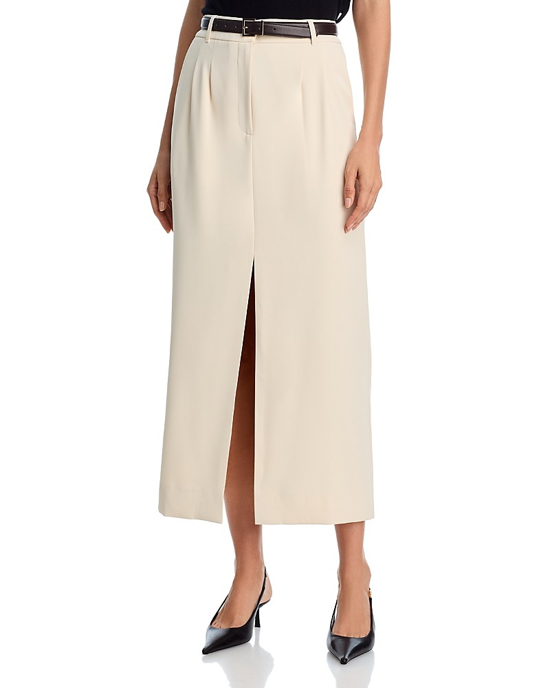 Beige midi skirt with a front slit, pleated design, and a black belt, paired with black high heels, showcasing a sophisticated and elegant style.