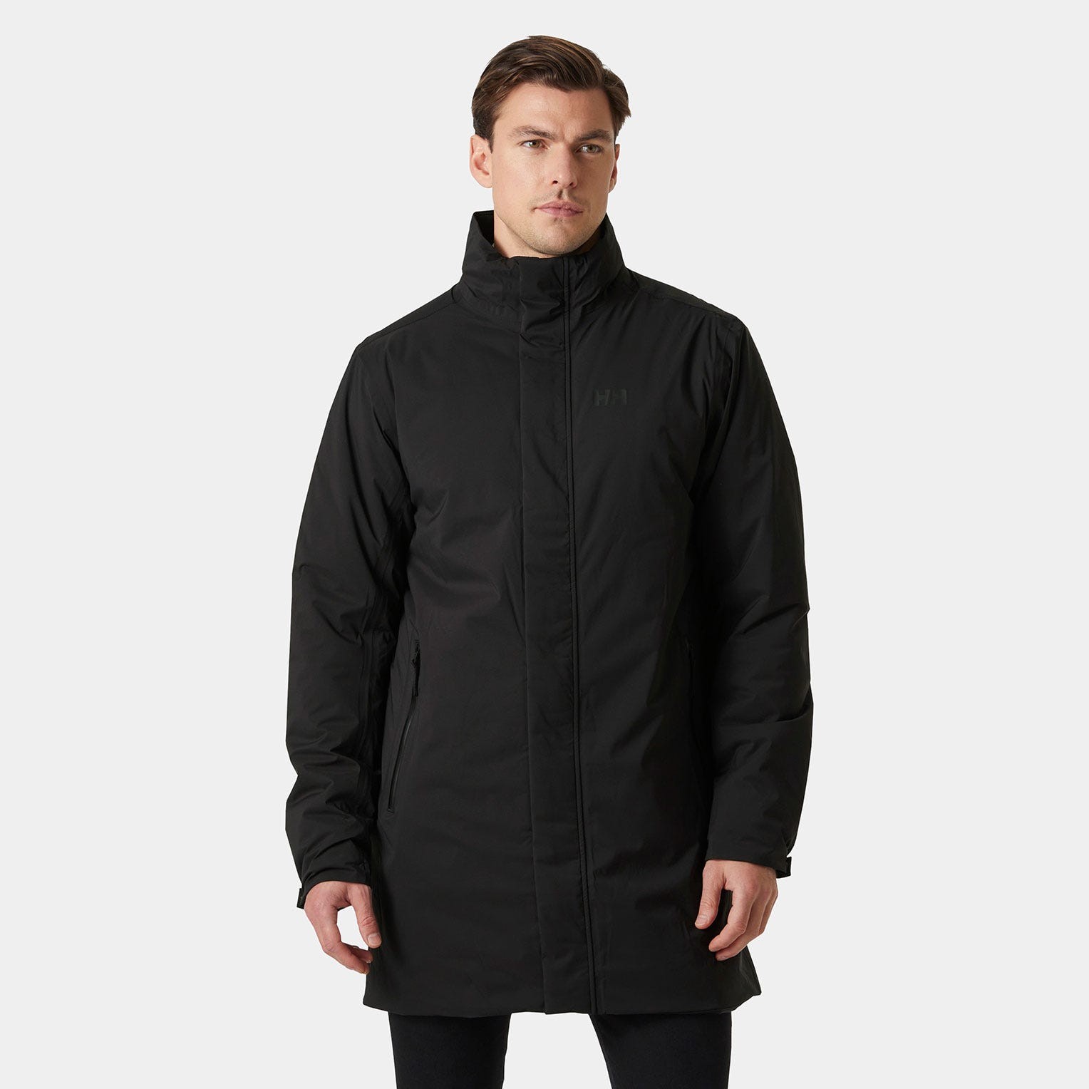 Long black waterproof jacket by Helly Hansen, featuring a high collar, zippered front, and side pockets, made from durable material for protection against the elements.
