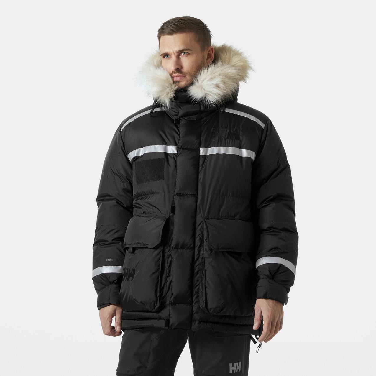 Black long hooded down jacket with reflective stripes and a fur-lined hood, featuring a zip closure and multiple pockets, designed for cold weather by Helly Hansen.