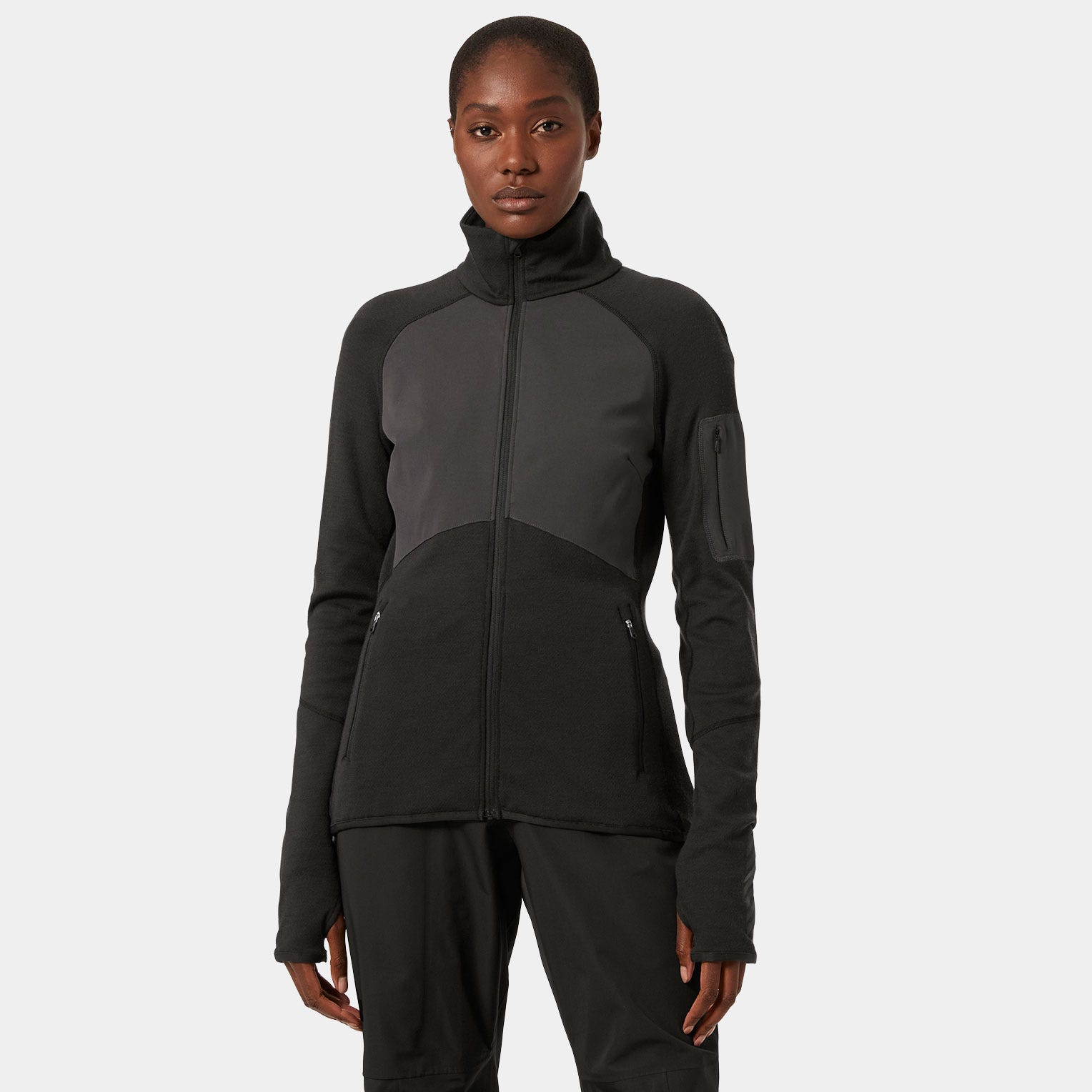 Black women's Merino wool fleece jacket by Helly Hansen, featuring a high collar, zippered pockets, and contrasting panel design for warmth and style.