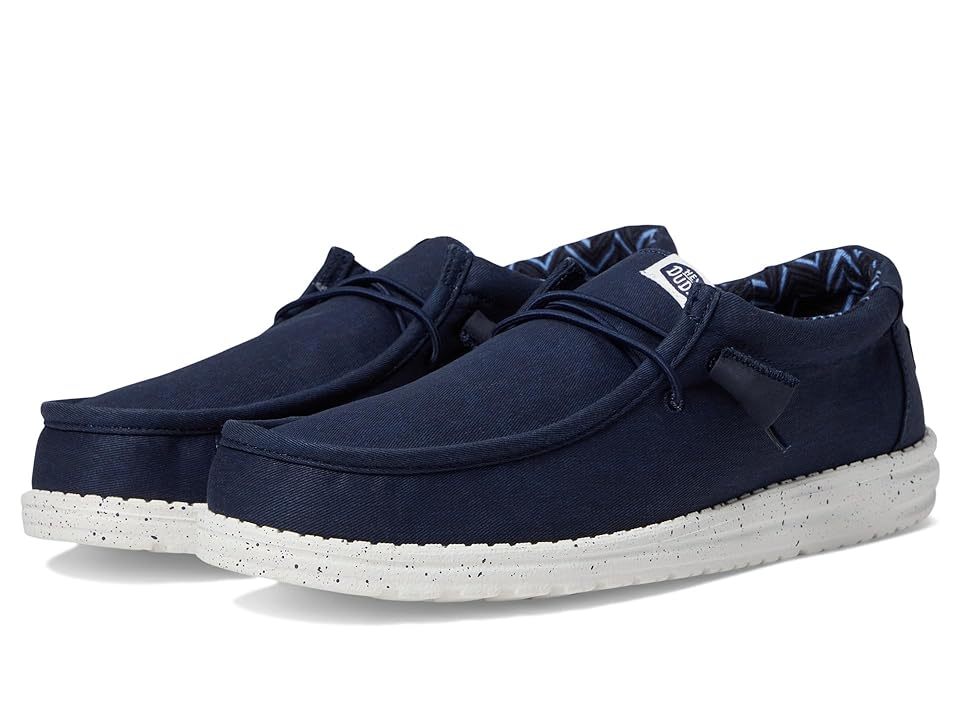 Navy stretch canvas slip-on shoes with a white speckled sole, featuring a relaxed fit and a decorative lace detail, size 11 by Hey Dude.