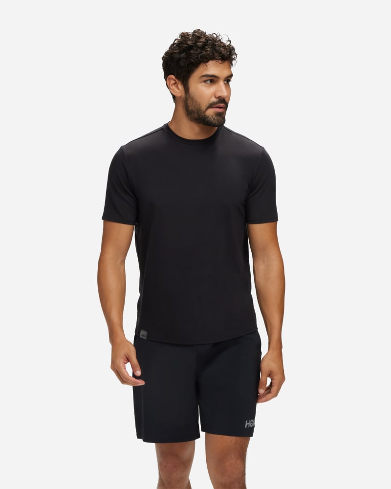 Men's HOKA Essential Shirt in medium size, featuring a sleek black design, short sleeves, and a lightweight, breathable fabric ideal for active wear.