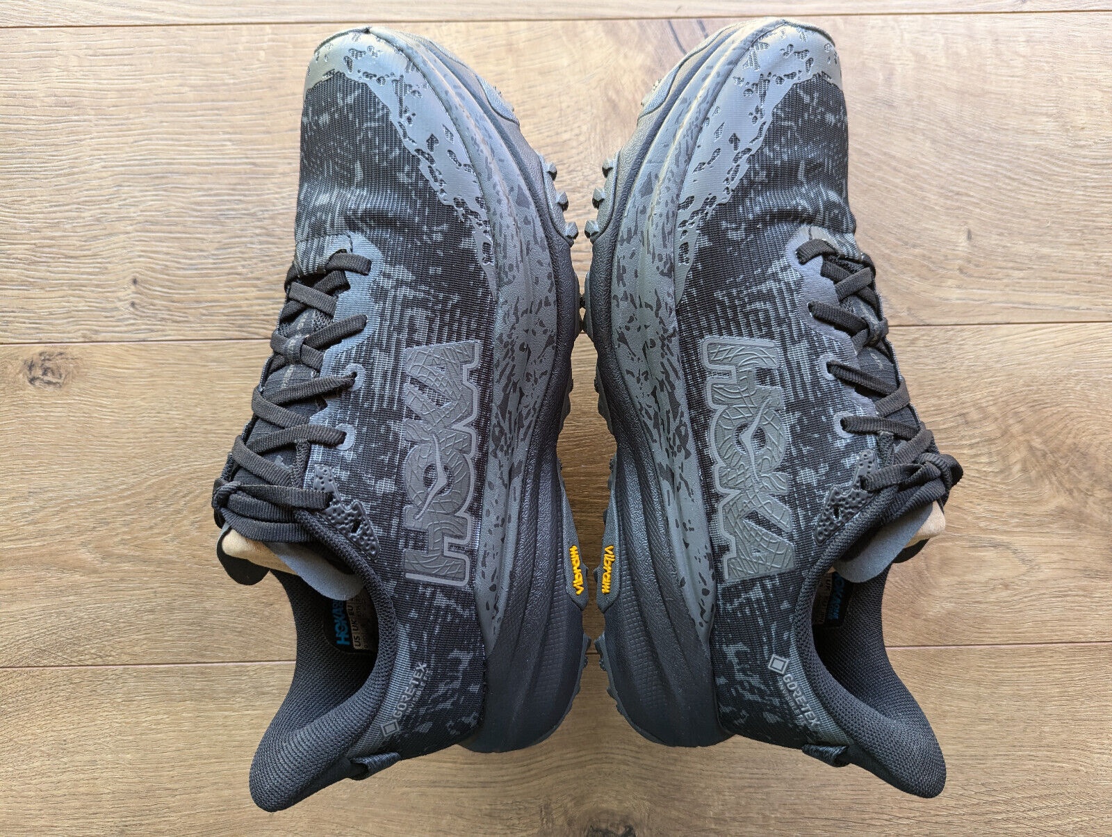 HOKA Men's Speedgoat 6 GORE-TEX Trail Shoes in Black/Outer Orbit, featuring a textured upper, durable rubber outsole, and size 9 label, designed for trail running.