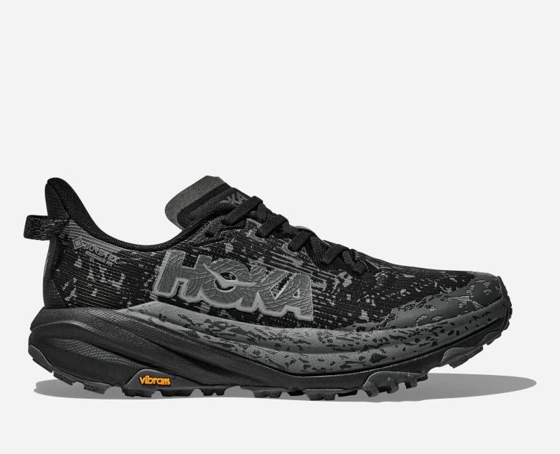 HOKA Women's Speedgoat 6 GORE-TEX Trail Shoes in black with a textured upper, featuring a prominent logo, rugged sole, and Vibram outsole for enhanced traction, size 10.5.