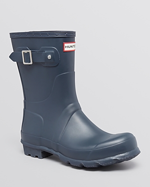 Navy short Wellington boots by Hunter, made of durable rubber, featuring a buckle detail on the side and a textured sole for grip.