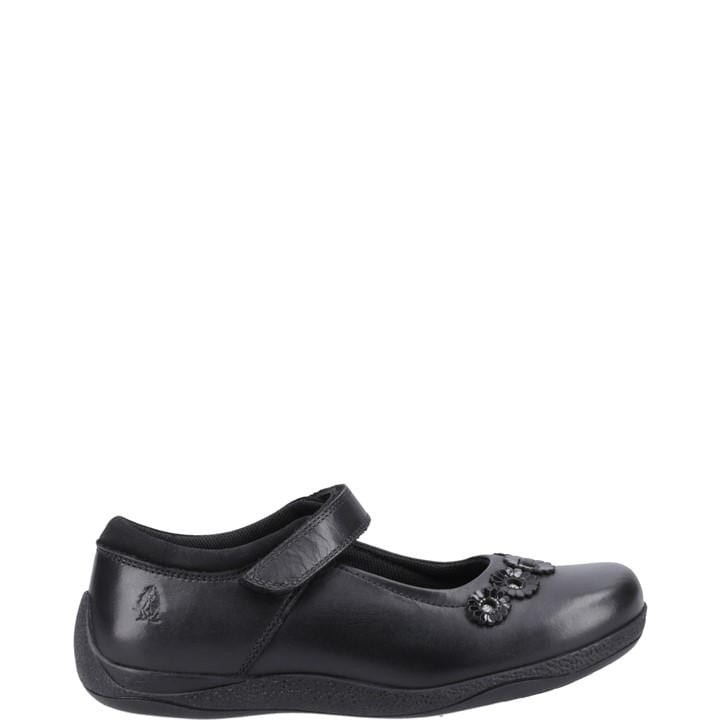 Black leather junior shoes featuring a Mary Jane style with a strap, embellished with decorative floral accents on the toe, and a textured rubber sole for grip.