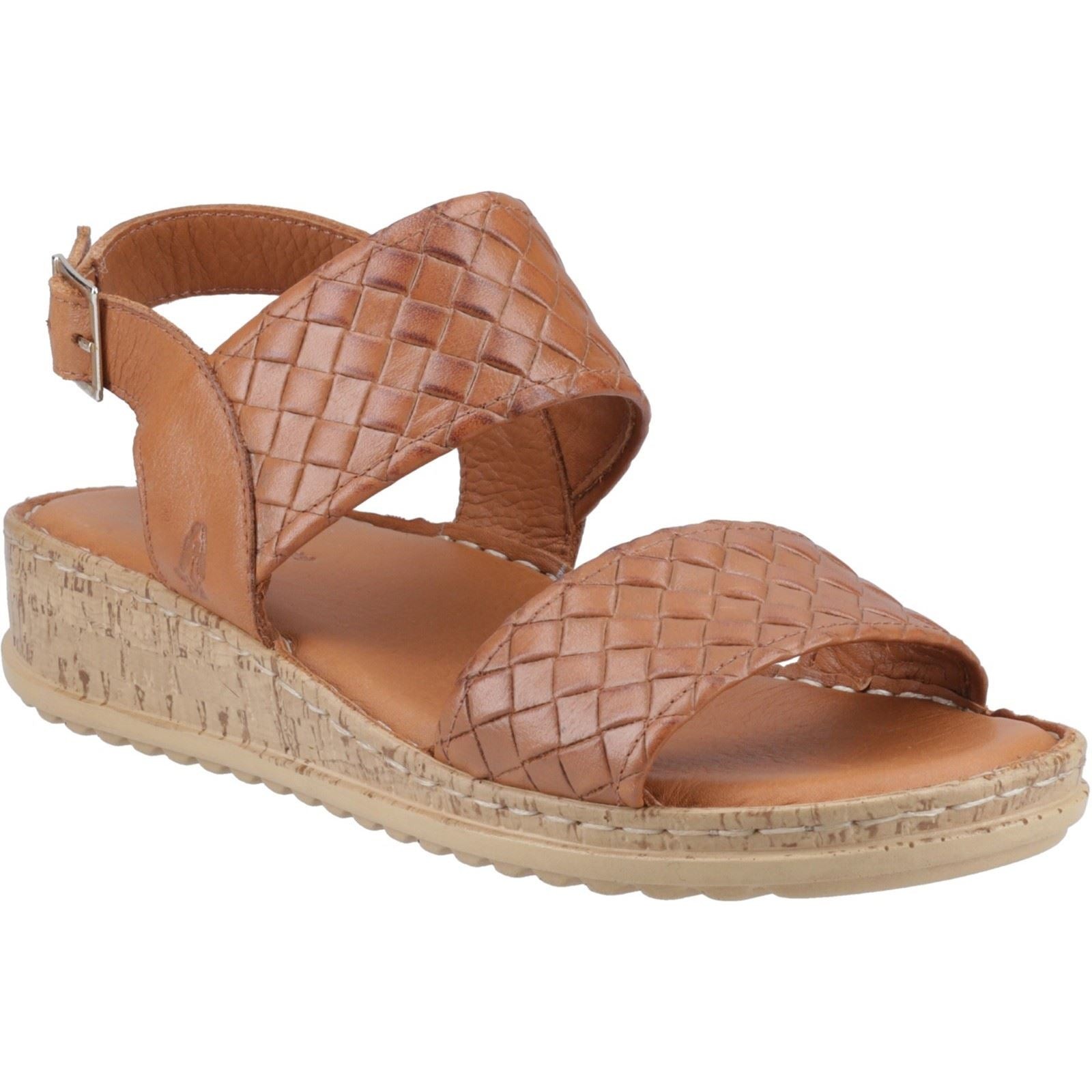 Tan woven leather sandal with two crisscross straps, a cork wedge sole, and an adjustable ankle strap, featuring a textured finish for added style.