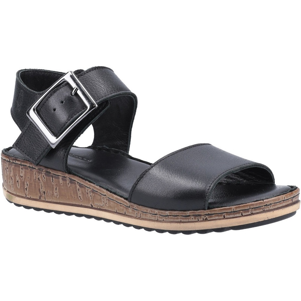 Black Hush Puppies Ellie Sandal featuring a wide strap, adjustable buckle, and a textured cork-like sole for comfort and style.