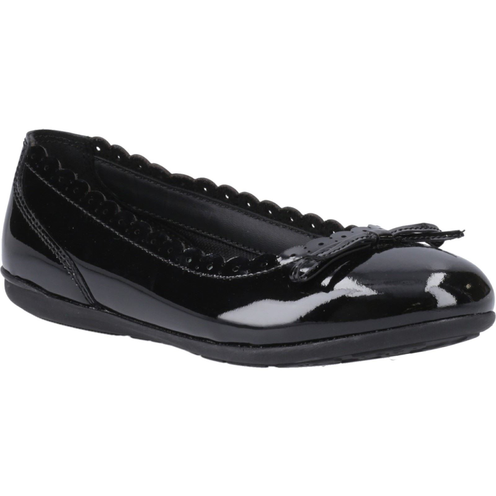 Black patent leather ballet flats featuring a round toe, scalloped trim, and a decorative bow on the front, designed for juniors by Hush Puppies.