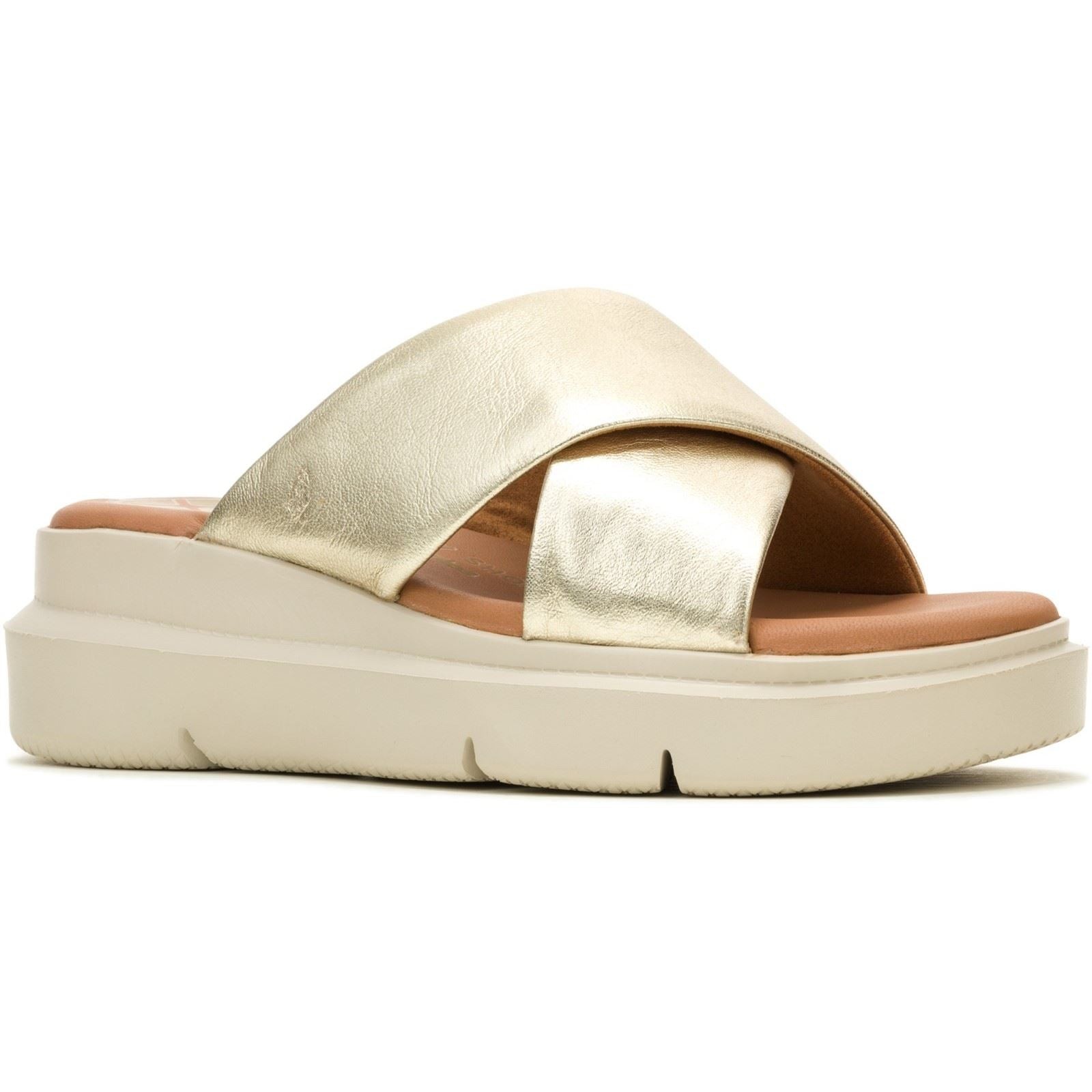 Champagne-colored leather sandals with a wide, crisscross strap design and a cushioned footbed, featuring a thick, white platform sole for added height and comfort.