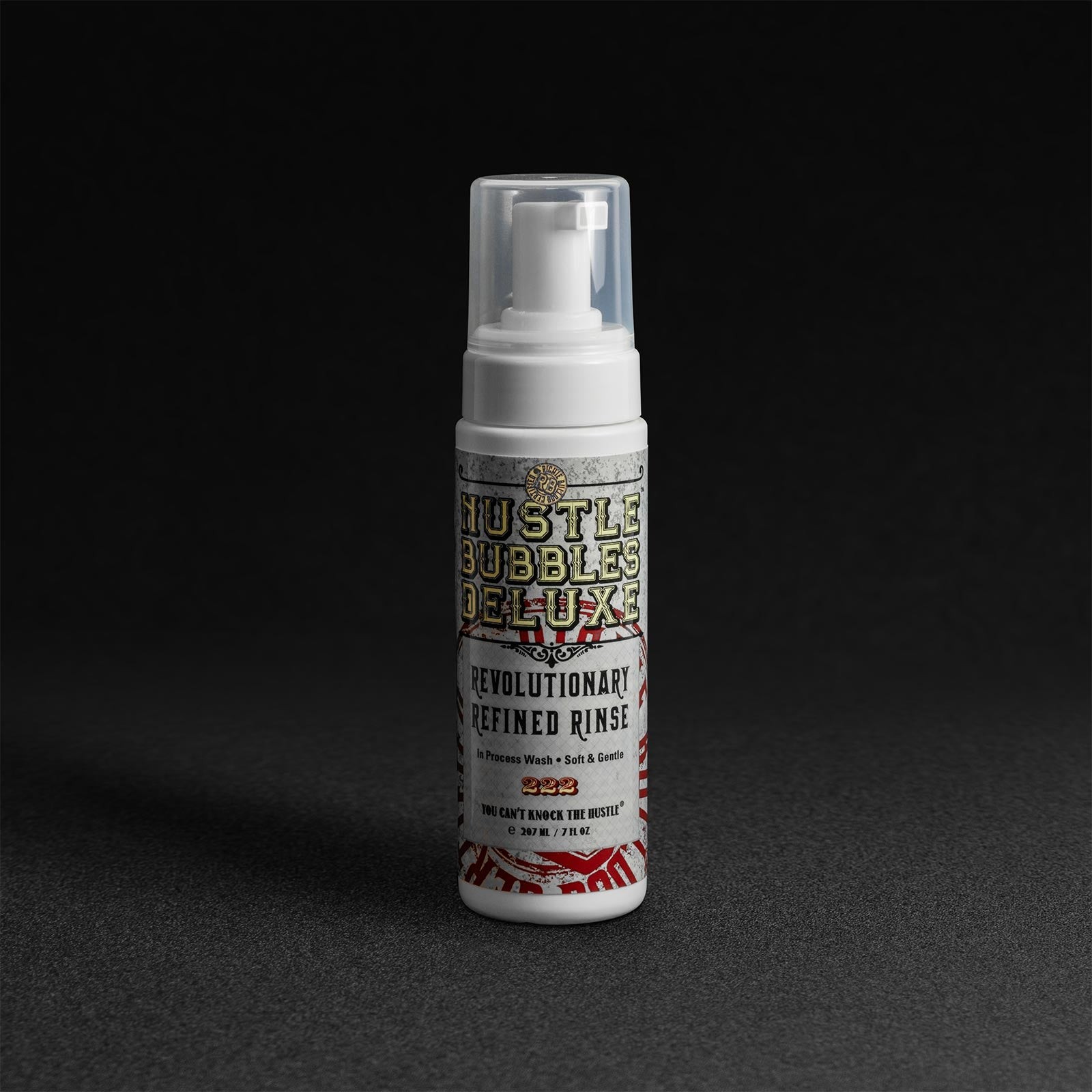 Hustle Bubbles Deluxe® Foam Wash in a white and black bottle with a clear pump top, featuring colorful, bold text and a floral design on a dark background.