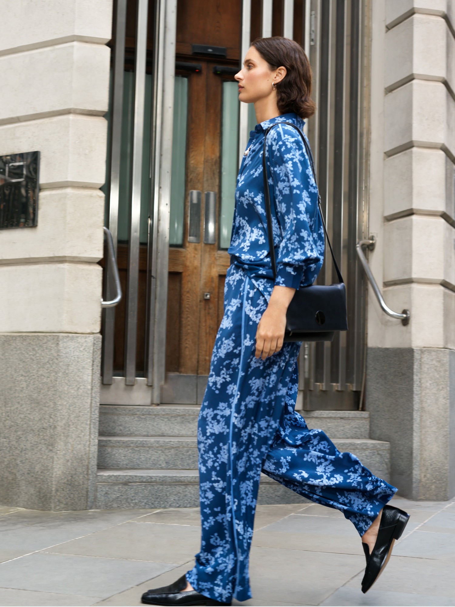 Floral straight leg trousers in blue multi by French Connection, featuring a vibrant floral print, lightweight fabric, and a relaxed fit, styled with a matching top and black accessories.