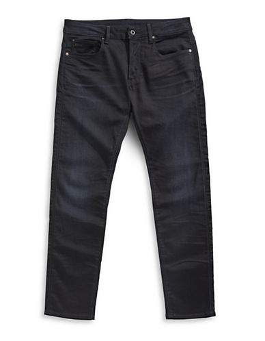 Slim-fit dark denim jeans featuring a classic five-pocket design, subtle fading, and G-Star branding on the back pocket.
