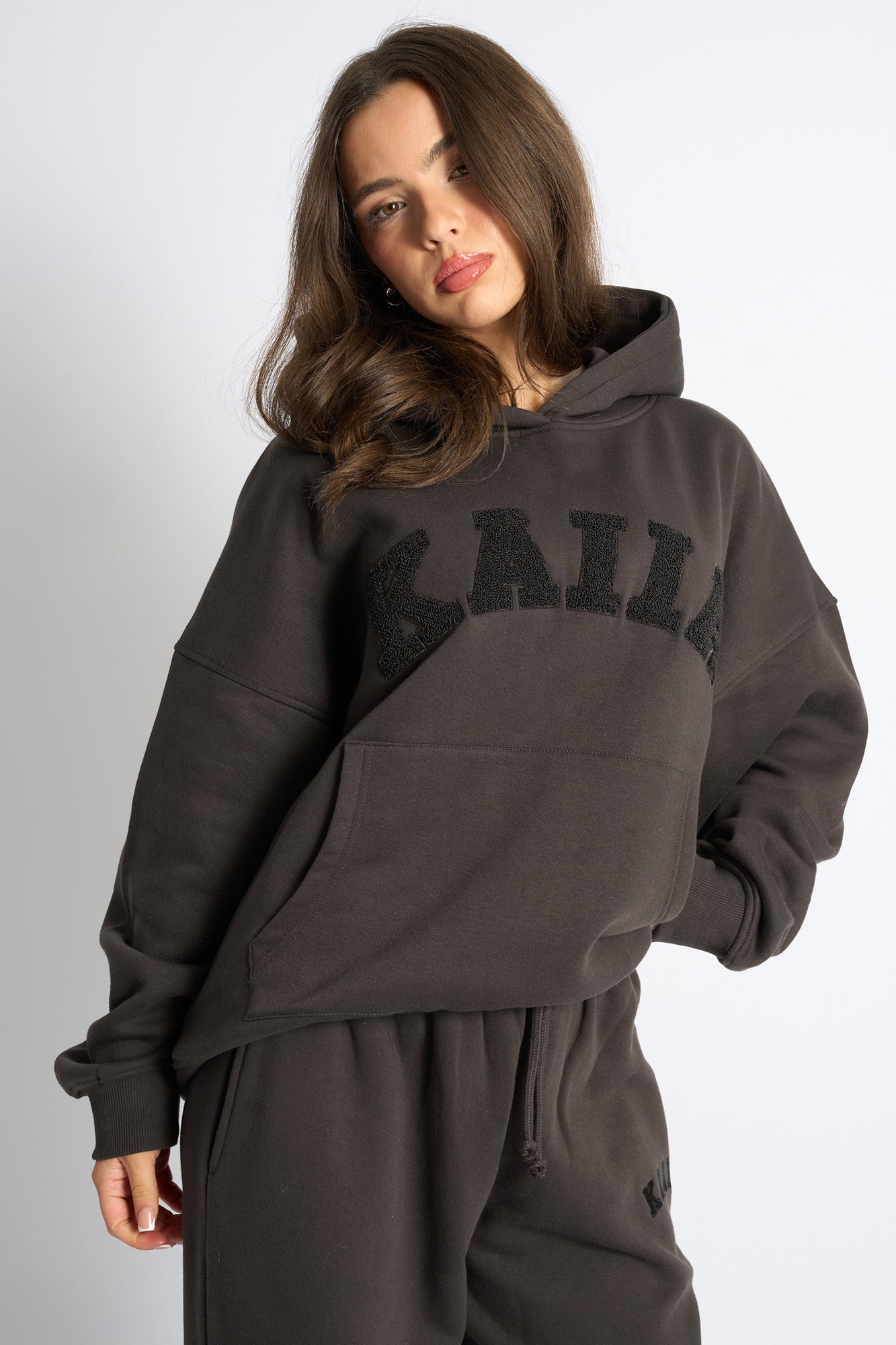 Oversized chocolate brown hoodie featuring a textured black "KAIIA" slogan on the front, with a spacious kangaroo pocket and a cozy hood.