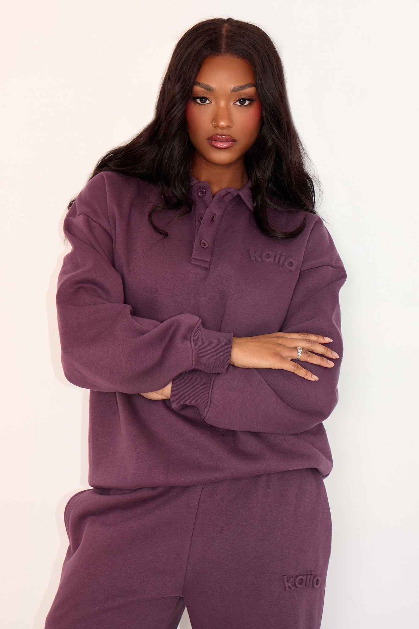 Aubergine polo sweatshirt by Kaiia, featuring a buttoned collar and embossed logo, made from soft material, styled with relaxed fit and long sleeves.