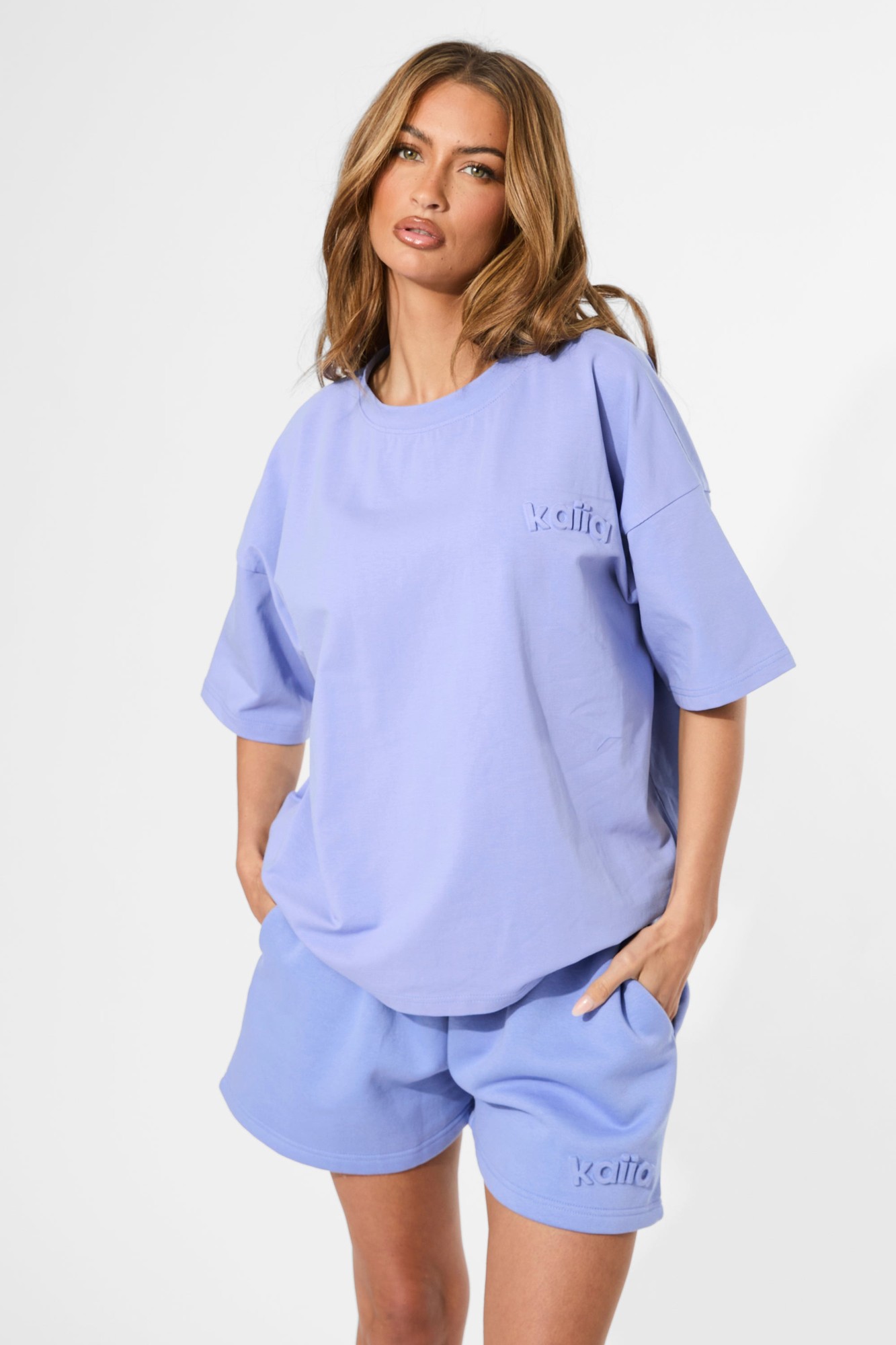 Cornflower blue oversized tee made of soft material, featuring an embossed logo on the chest, with relaxed short sleeves and a comfortable fit.