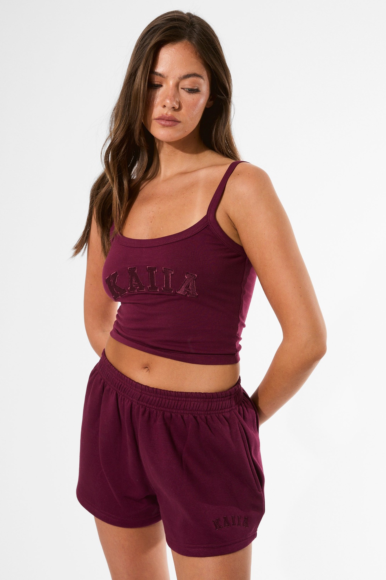 Deep burgundy cami top featuring the "Kaiia" logo in a textured design, made from a soft, stretchy material with thin adjustable straps.
