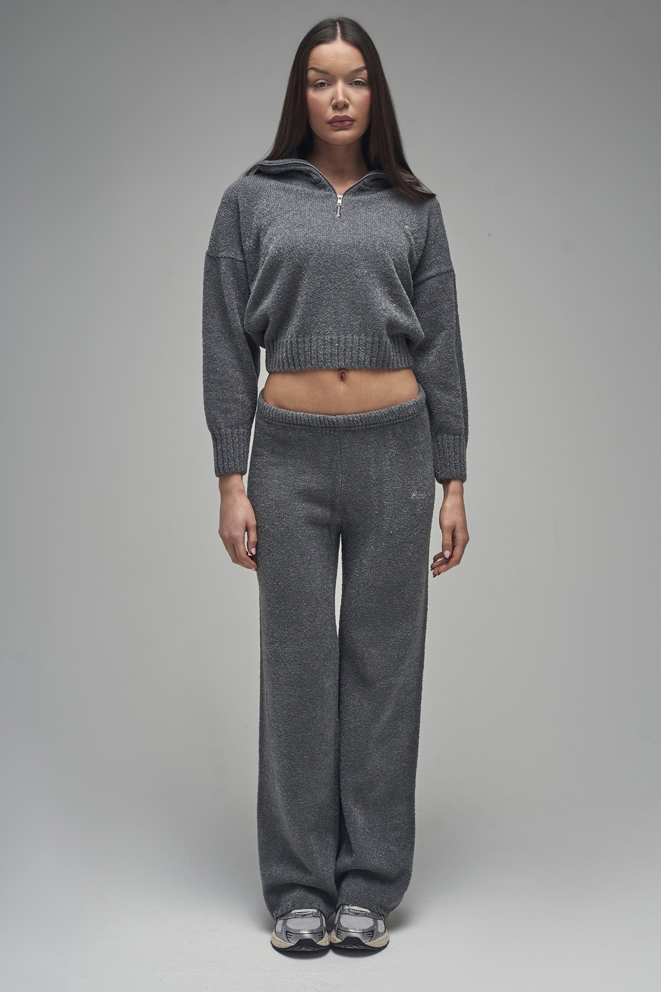 Charcoal wide-leg trousers made from a soft knit material, featuring a relaxed fit and an elastic waistband, styled with a matching cropped sweater.