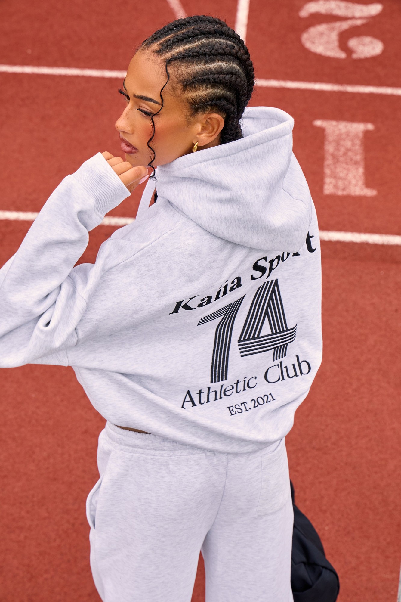 Oversized grey marl hoodie featuring black "Kaiia Sport 74 Athletic Club EST. 2021" graphic on the back, with a drawstring hood and soft, comfortable material.