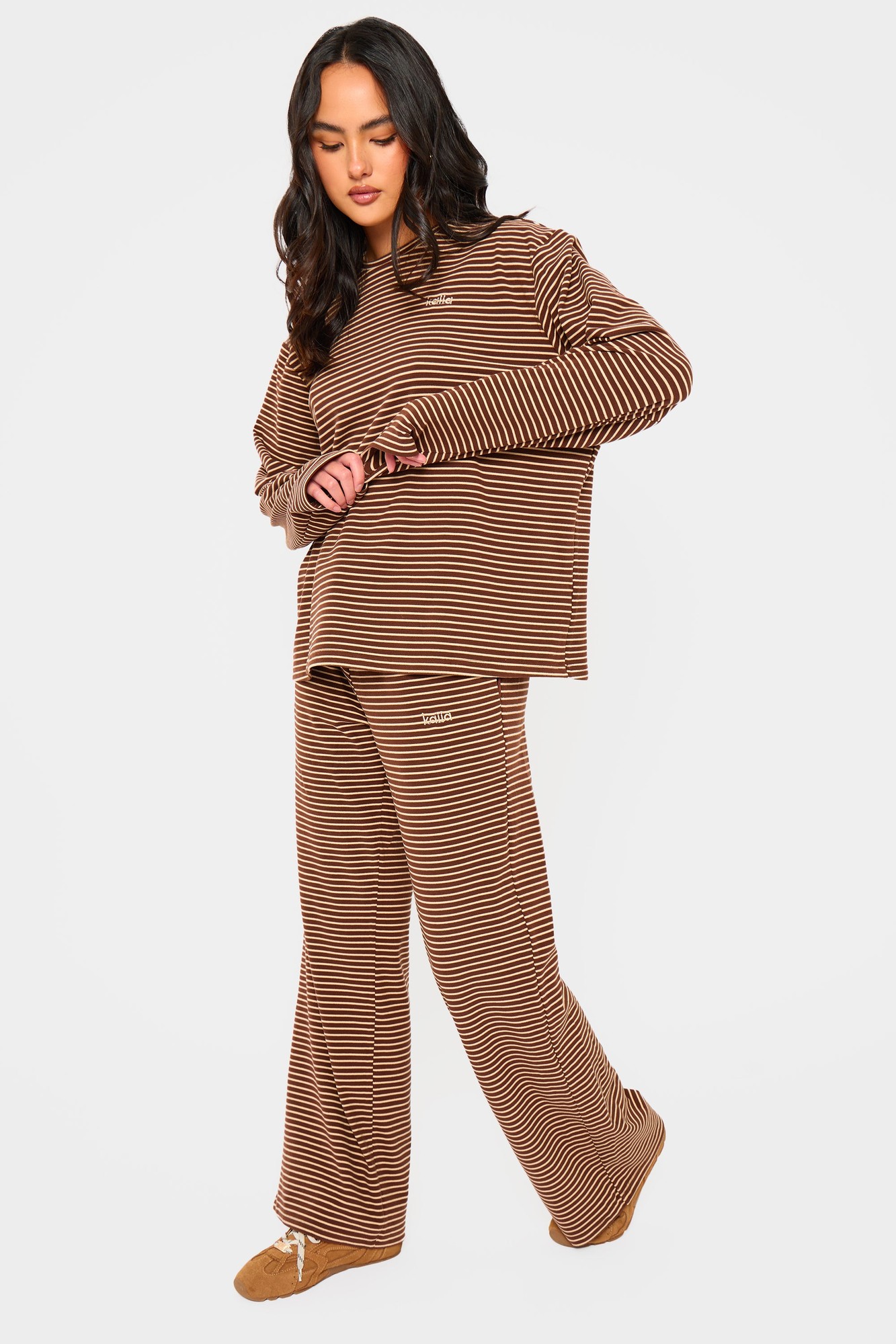 Brown and cream striped fleece wide-leg trousers with a drawstring waist, styled with a matching oversized top for a cozy, relaxed look.