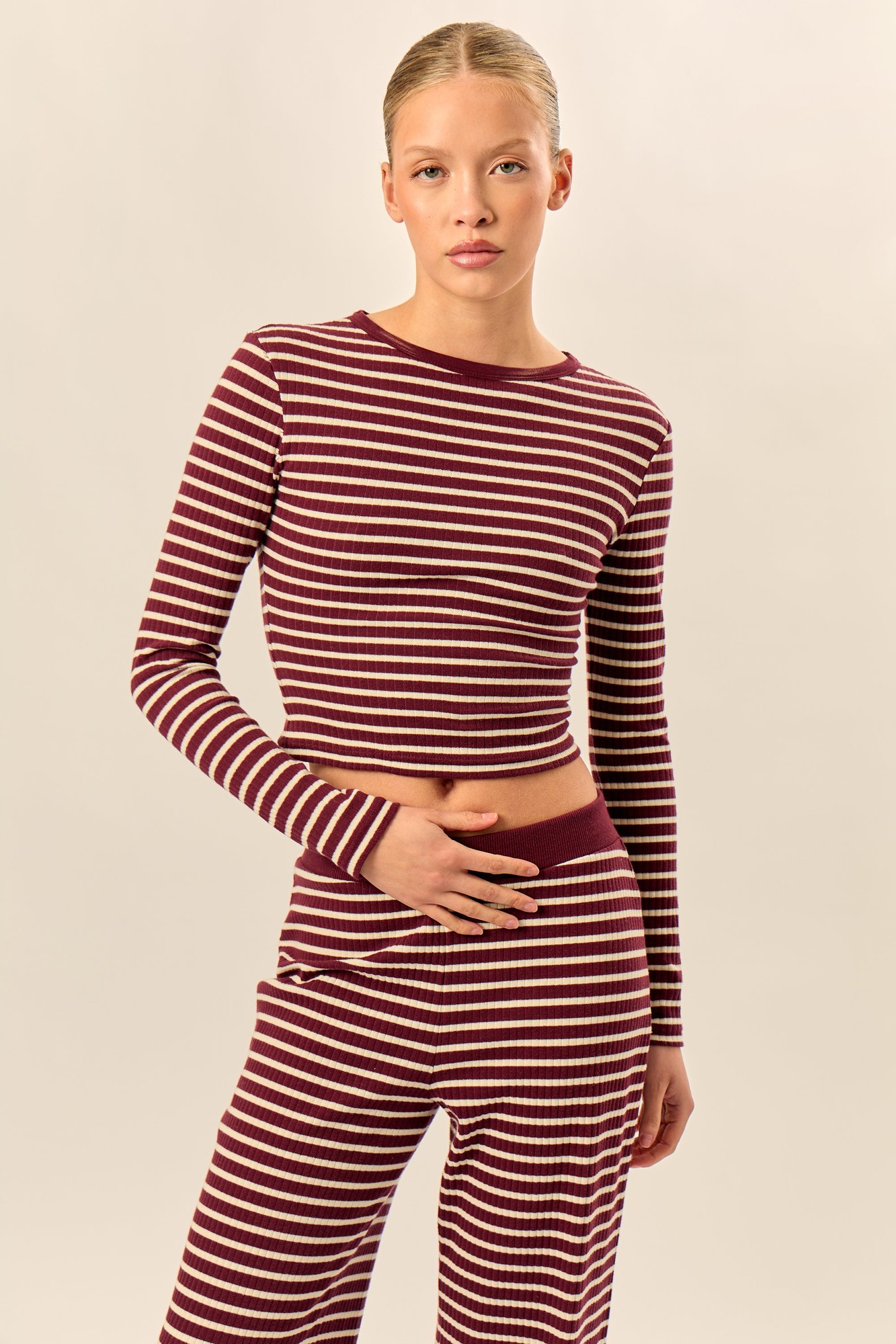 Dark cherry and cream striped rib fitted long sleeve baby tee with a round neckline and a cropped silhouette, styled with matching pants.