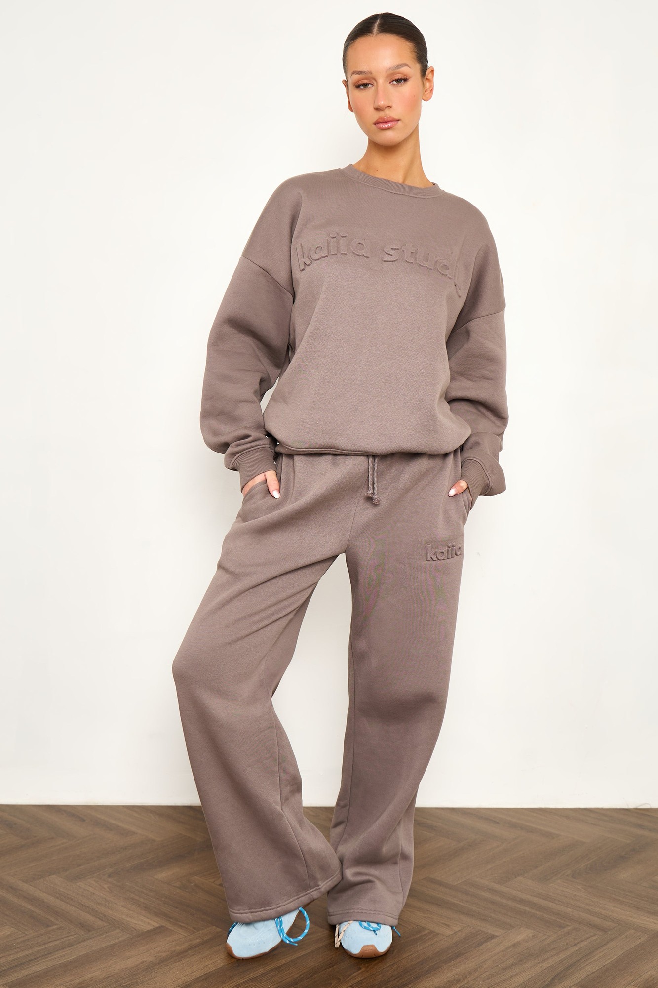 Oversized storm grey sweatshirt with embossed "Kaiia Studio" logo, made of soft material, paired with matching sweatpants for a relaxed look.
