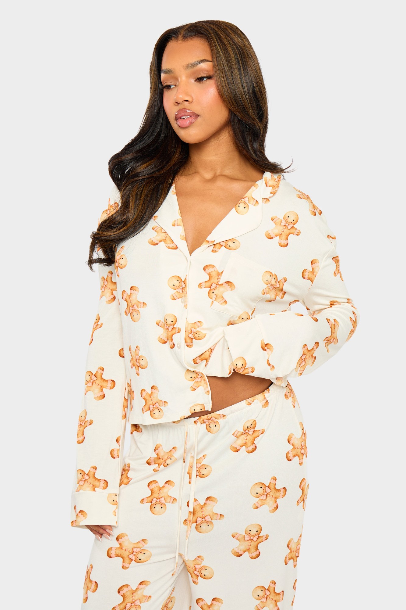 Cream pyjama shirt featuring a slouchy fit, button-up front, and playful gingerbread man print in brown, made from a soft, comfortable material.