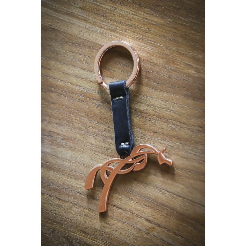 Copper horse-shaped keychain with a black leather strap and a rose gold metal ring, elegantly designed with intertwined details.