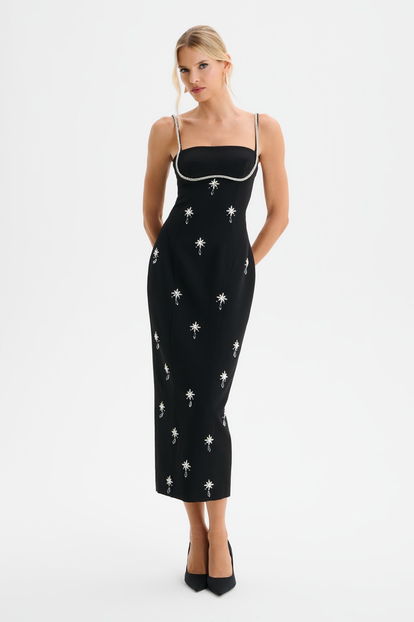 Black midi dress with hand-embellished daisy motifs, tailored contour fit, spaghetti straps, and a sleek silhouette, perfect for formal occasions.