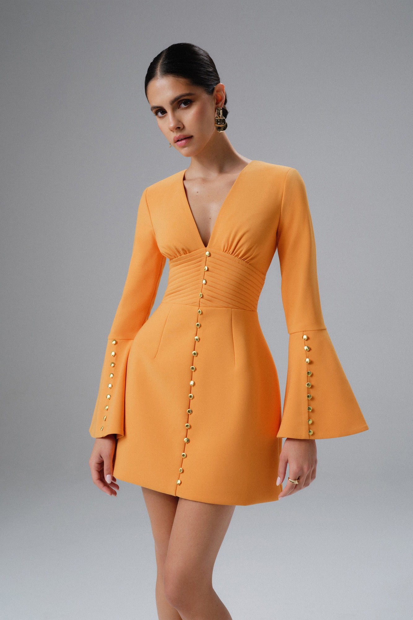 Orange mini dress by Lavish Alice features fluted sleeves, a deep V-neck, and micro buttons down the front, made from a structured material for a fitted silhouette.