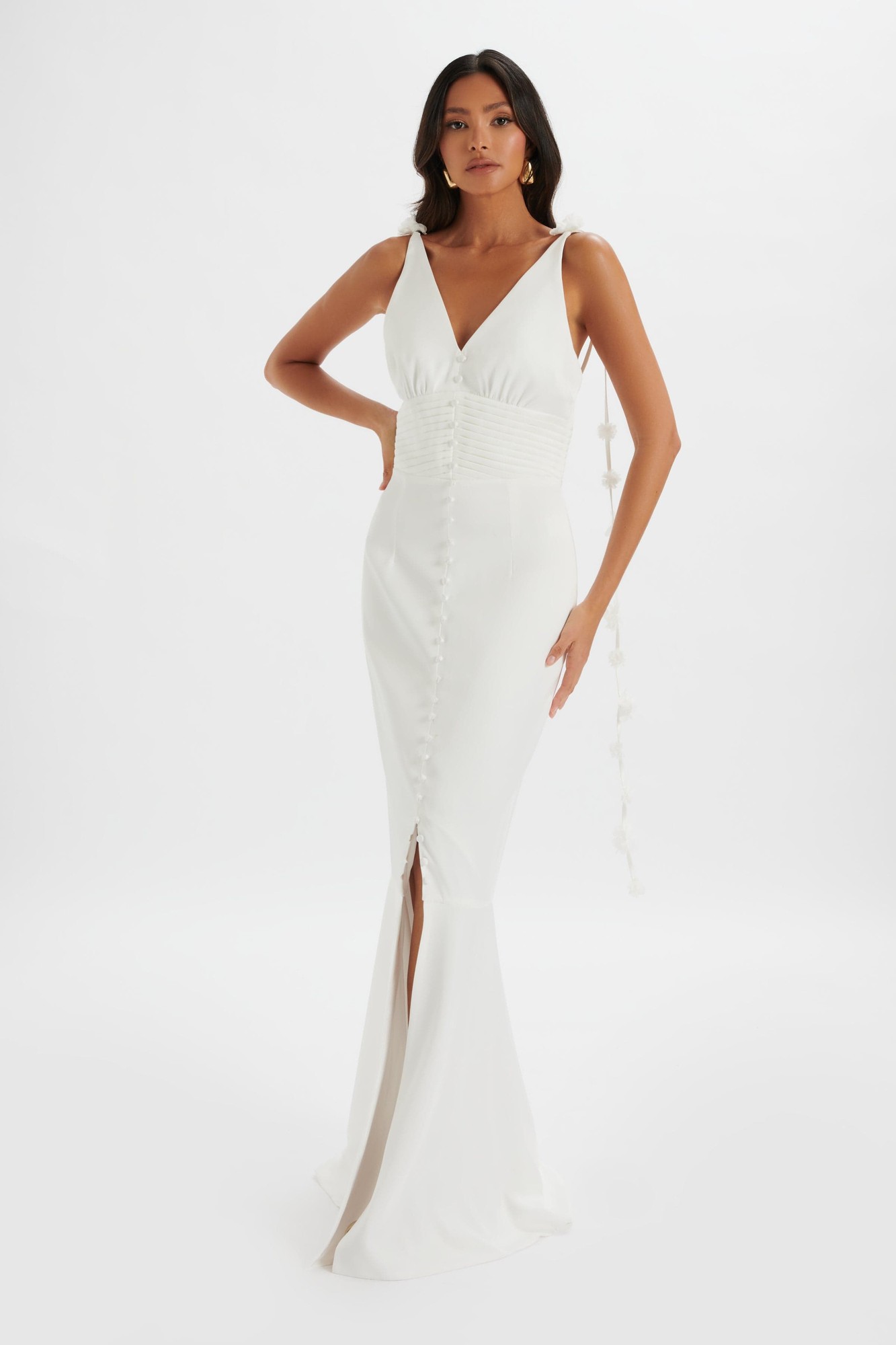 Ivory satin maxi dress featuring a fit and flare silhouette, floral strap details, a V-neckline, and a front slit with button accents.