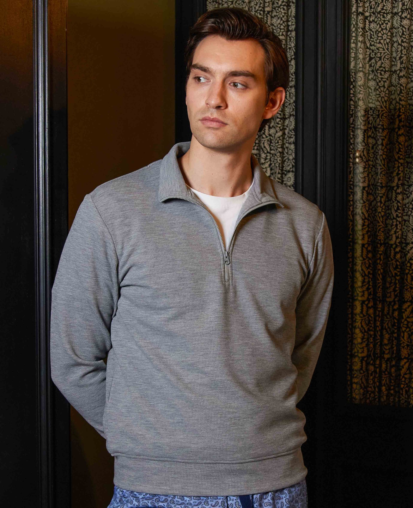 Marl grey half-zip waffle sweatshirt made from sweat-wicking material, featuring a collar and long sleeves, modeled by a man in a stylish indoor setting.