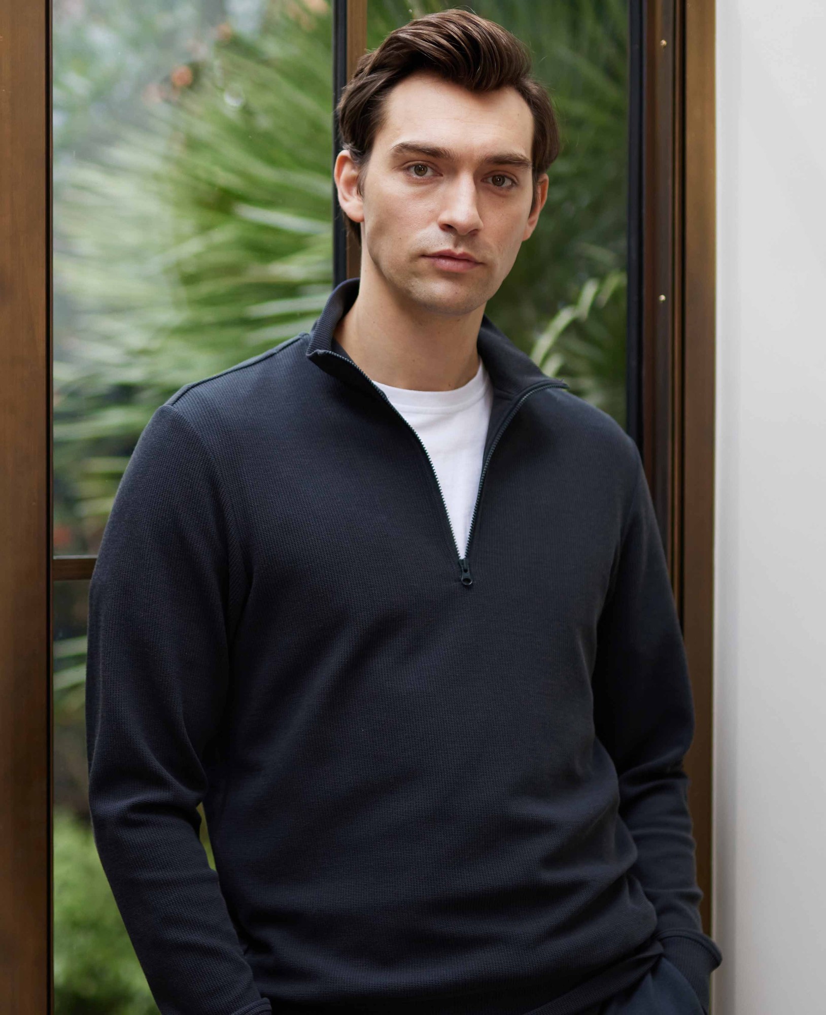 Men's navy half-zip waffle sweatshirt in size large, featuring a textured fabric, a zippered collar, and a relaxed fit, modeled by a man against a green backdrop.