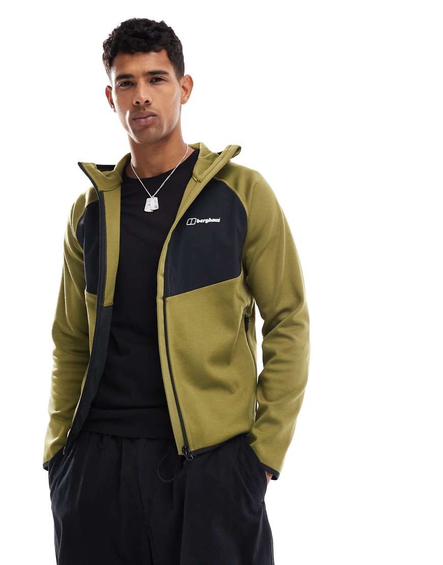 Green Berghaus Trawden Jacket featuring a black panel on the chest, zip closure, hood, and soft material, worn by a model against a white background.