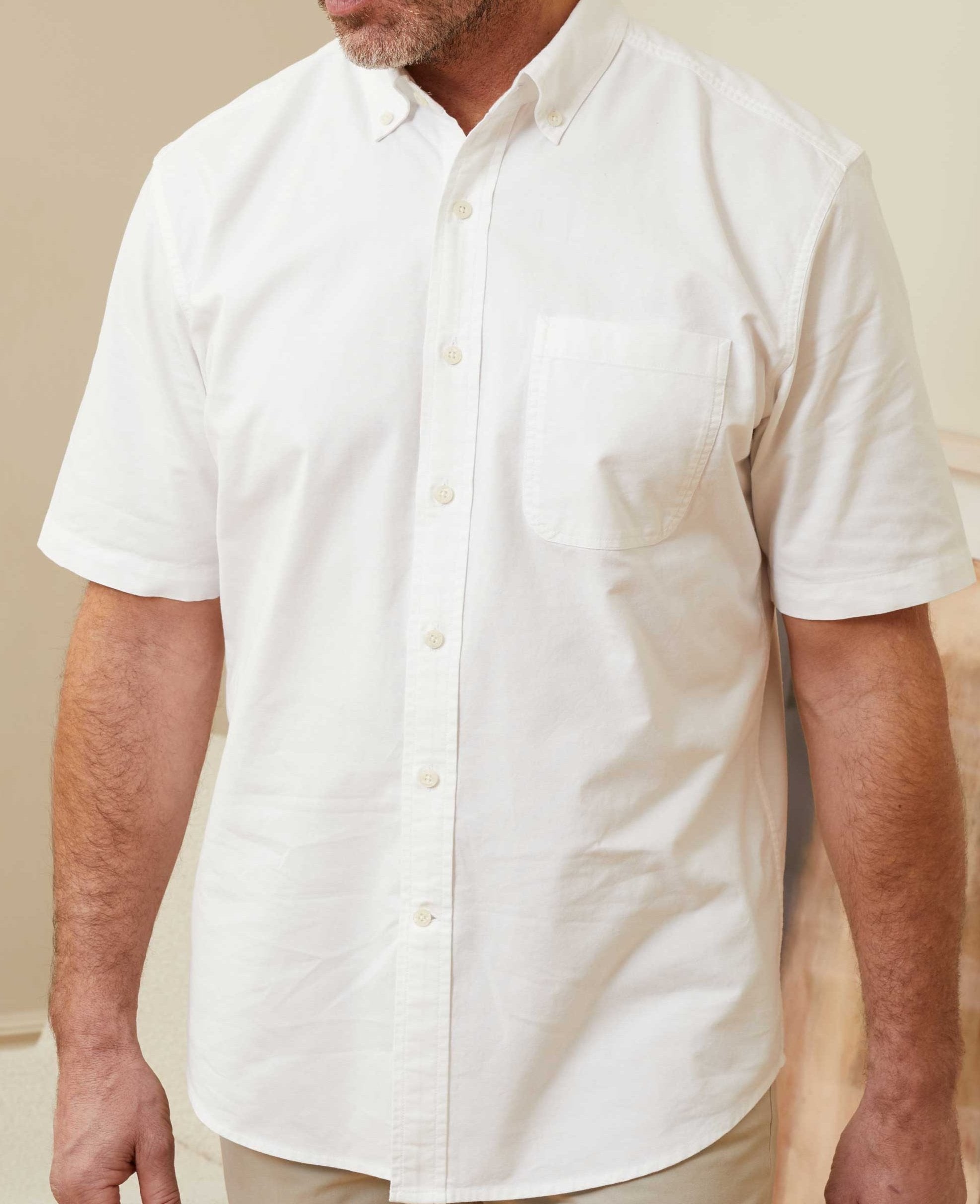 White short sleeve Oxford shirt with a classic fit, featuring a button-down collar and a single chest pocket, made from lightweight cotton material.
