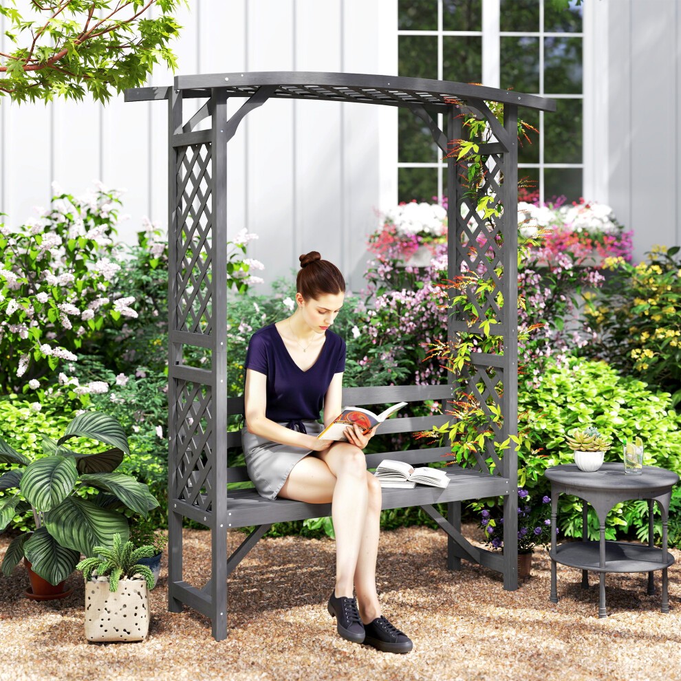 Grey wooden arch pergola garden bench with a lattice design, featuring a comfortable seat and surrounded by vibrant flowers and greenery.