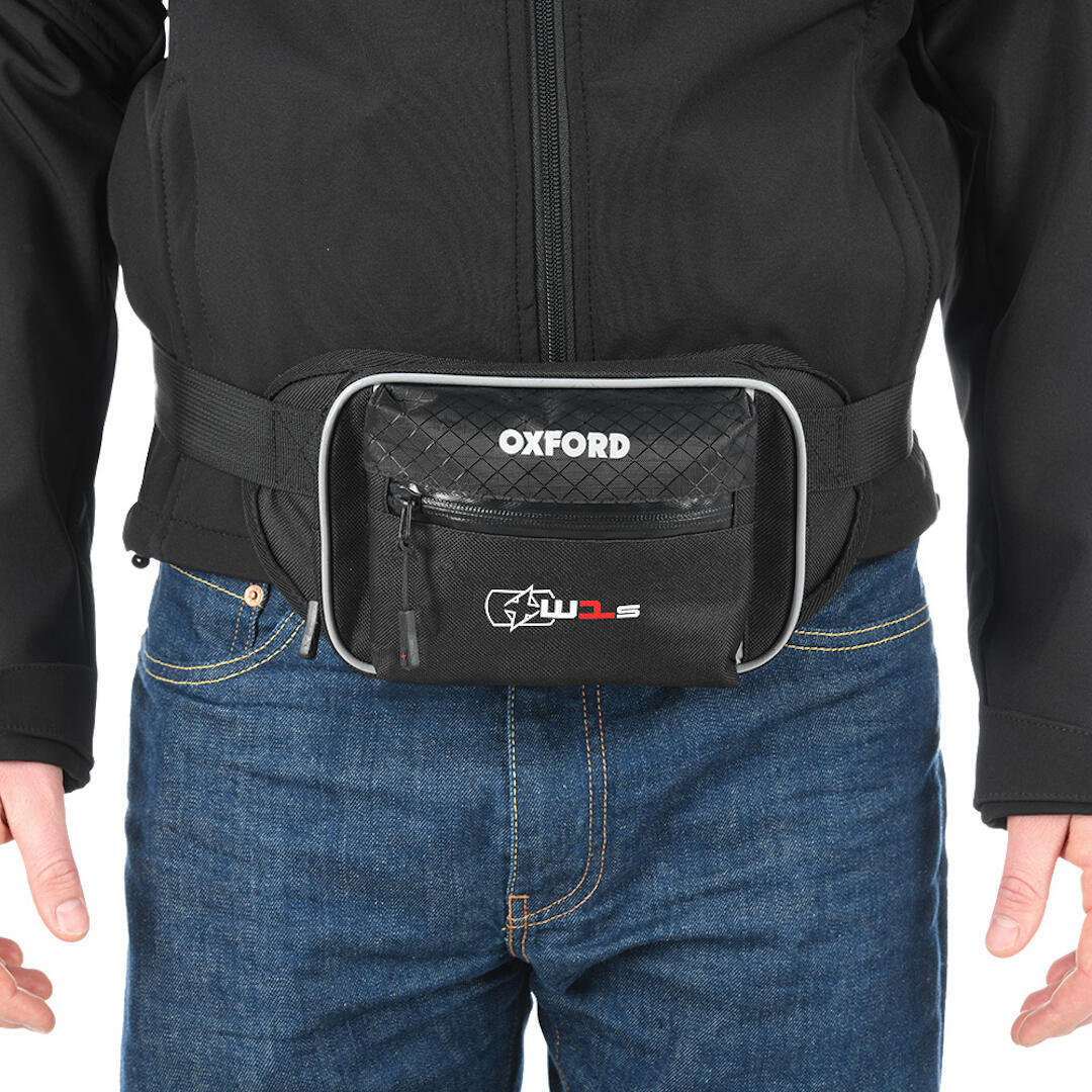 Black Oxford XW1S waist bag featuring a textured front, zippered pocket, and adjustable strap, worn over blue jeans and a black jacket.