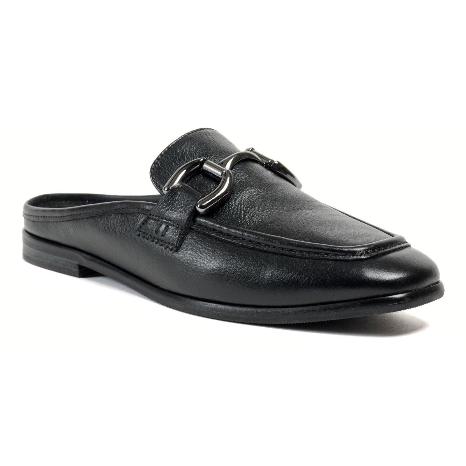 Black leather mule featuring a sleek design, rounded toe, and decorative silver buckle detail on the front, set on a low profile sole.