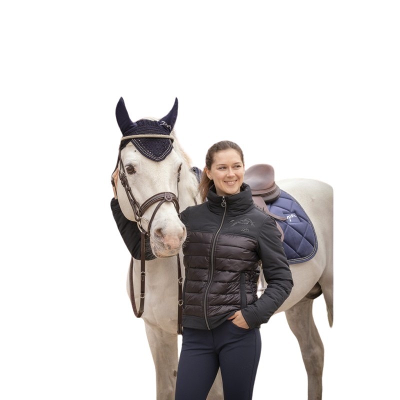 Black puffer jacket with a fitted design, featuring a high collar and zip closure, worn by a woman beside a gray horse, showcasing a navy saddle pad.