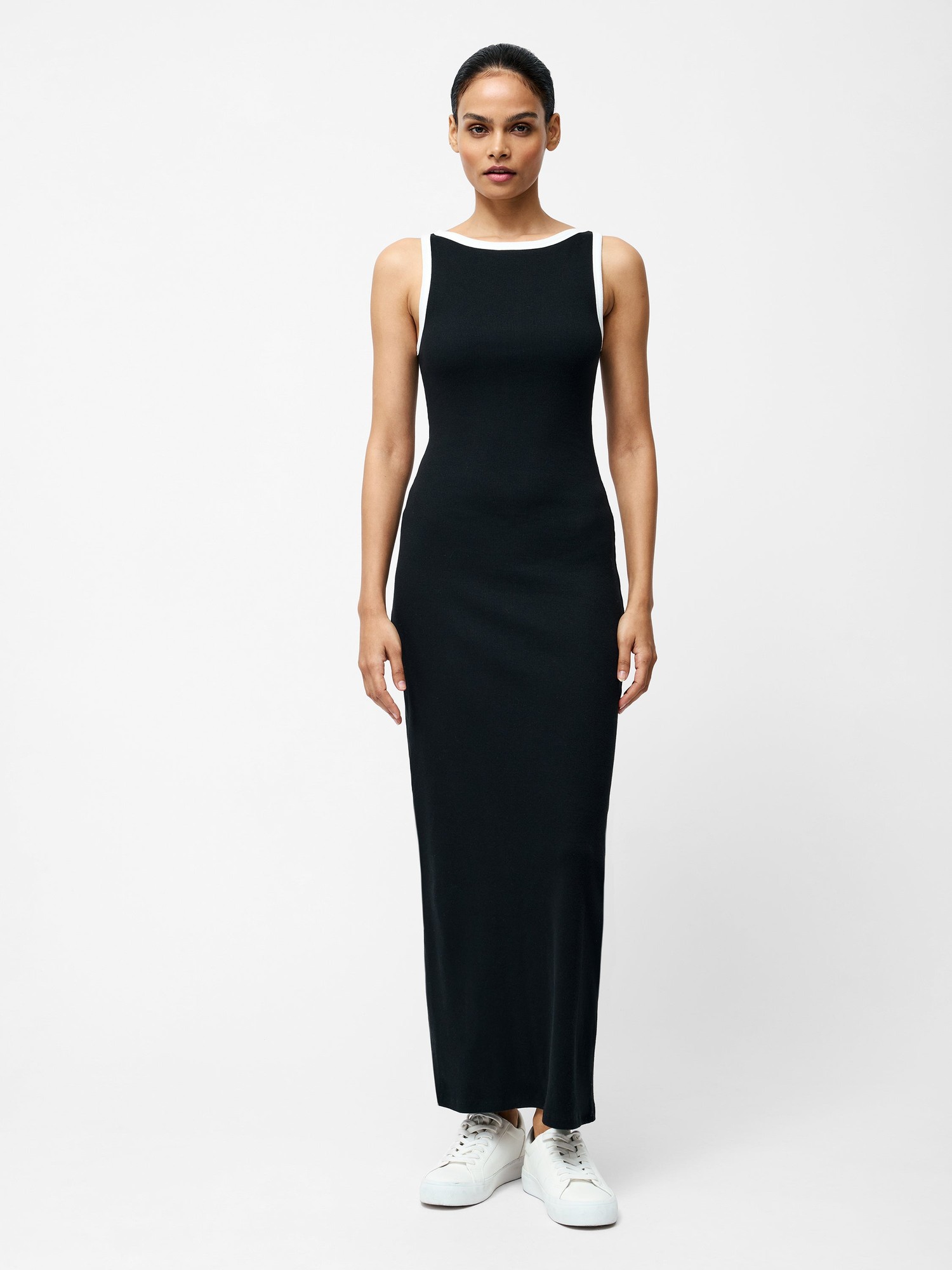 Black and white Rassia Slash Neck Dress by French Connection, featuring a sleek, fitted silhouette, slash neckline, and contrasting white straps, paired with white sneakers.
