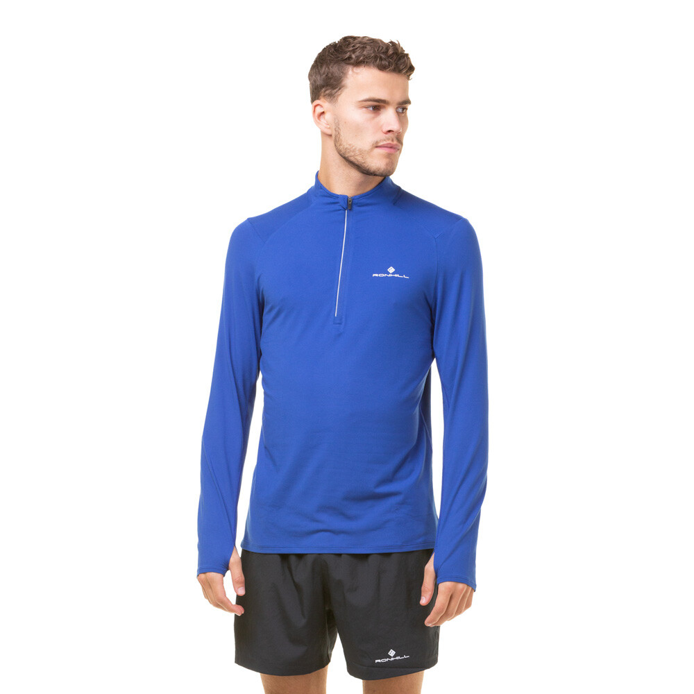 Blue thermal long-sleeve top with a half-zip collar, featuring a white logo on the chest, paired with black shorts, designed for men's activewear.