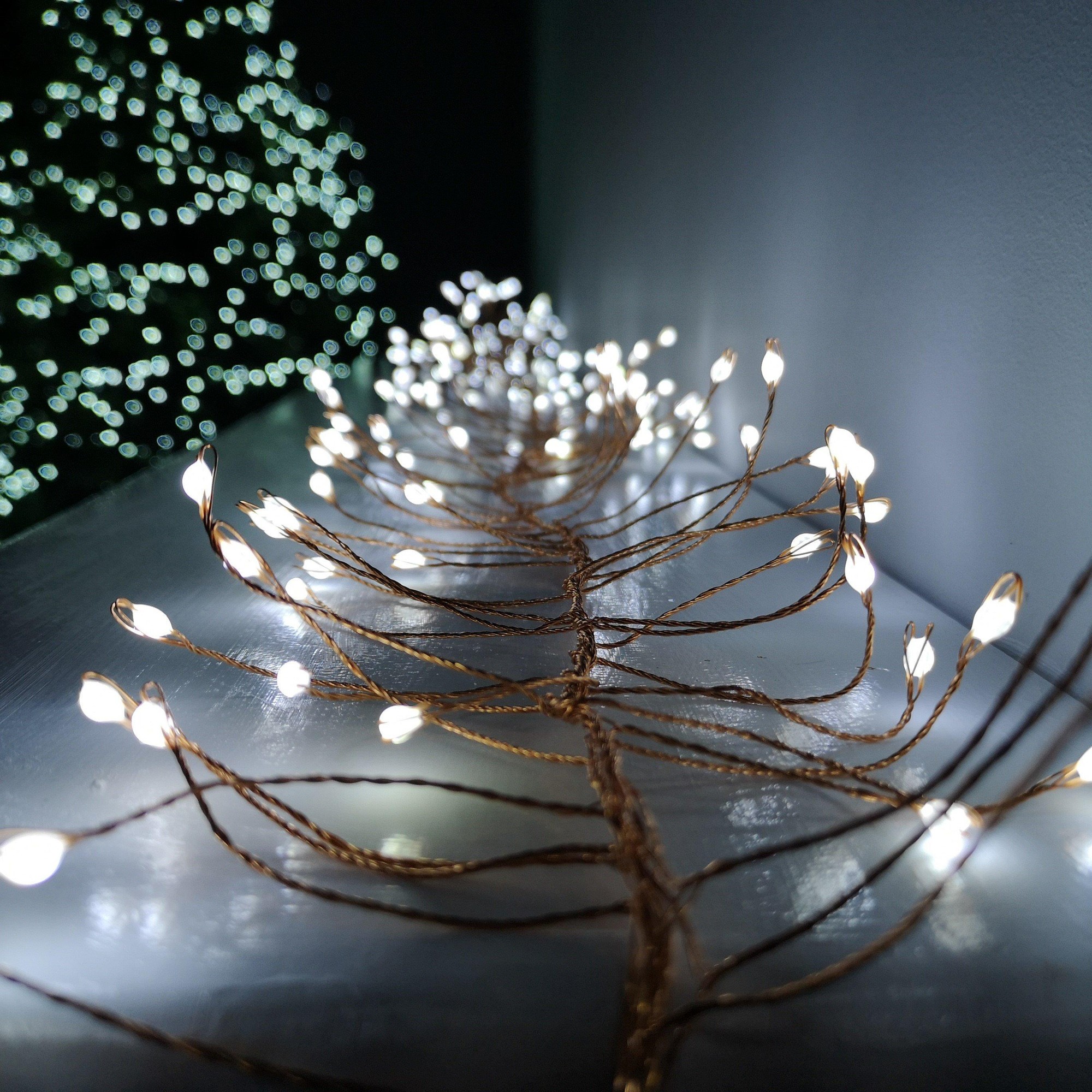Gold wire LED lights with cool white bulbs, featuring 8 functions, arranged in a 1.8m length, ideal for outdoor Christmas decoration.