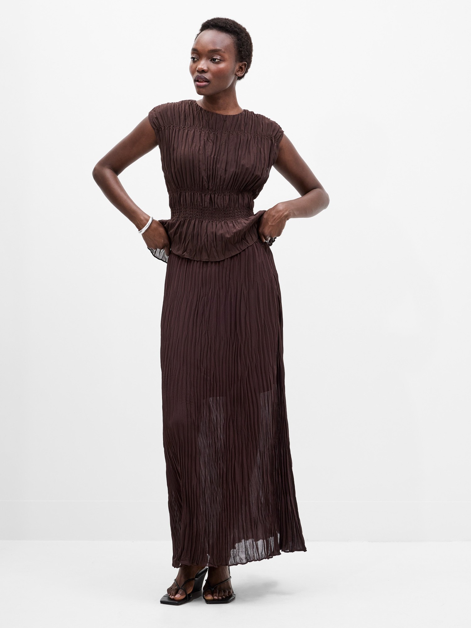 Bitter chocolate pleated overlay maxi skirt by French Connection, featuring a flowing design, cap sleeves, and a cinched waist for a stylish silhouette.