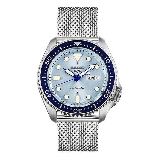 Seiko 5 Sports SRPE77K1 men's automatic watch featuring a 42.5mm light blue dial, blue bezel, silver mesh bracelet, and day-date display at 3 o'clock.