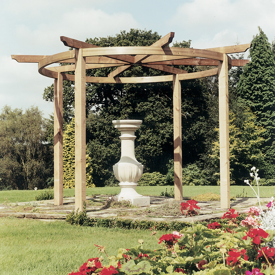 Brown wooden Grange Carousel Pergola with an open roof design, featuring sturdy beams and a central decorative stone column, surrounded by vibrant flowers and greenery.
