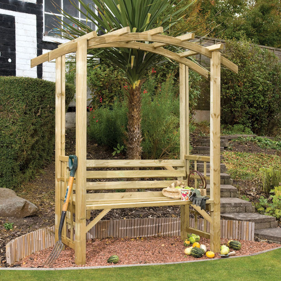 Wooden arched garden seat with a natural finish, featuring a slatted backrest and armrests, surrounded by greenery and decorative stones.